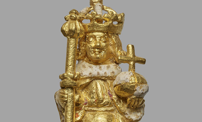 A close up of a gold figure of Henry VI holding a sceptre and orb