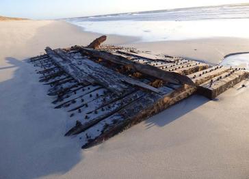 A section of timber from a shipwreck lying on a beach