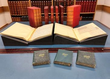 Papers from the John Galsworthy archive laid out on a table with volumes stood up, two lain open and three sat on the table